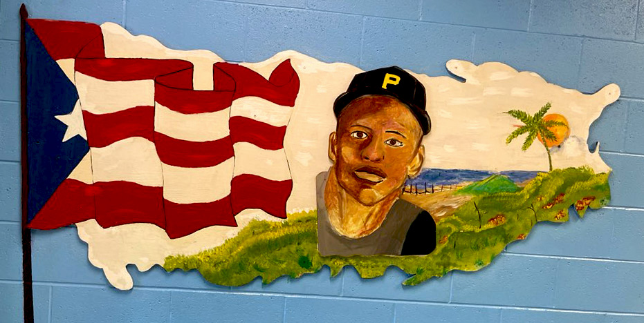 Colorful mural of Roberto Clemente with the Puerto Rican flag and island displayed inside Roberto Clemente Middle School.